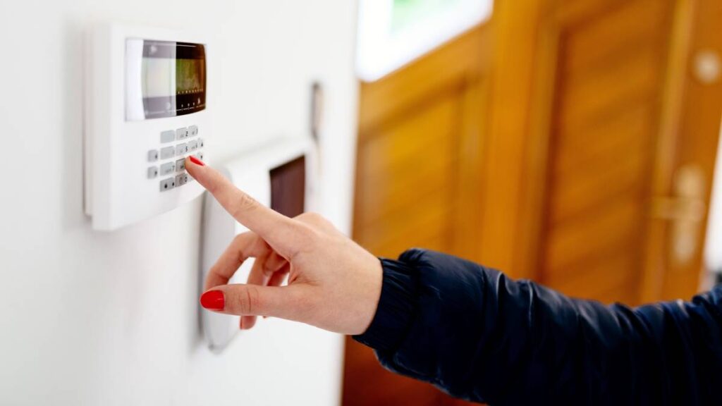 young,woman,entering,security,code,on,home,security,alarm,system